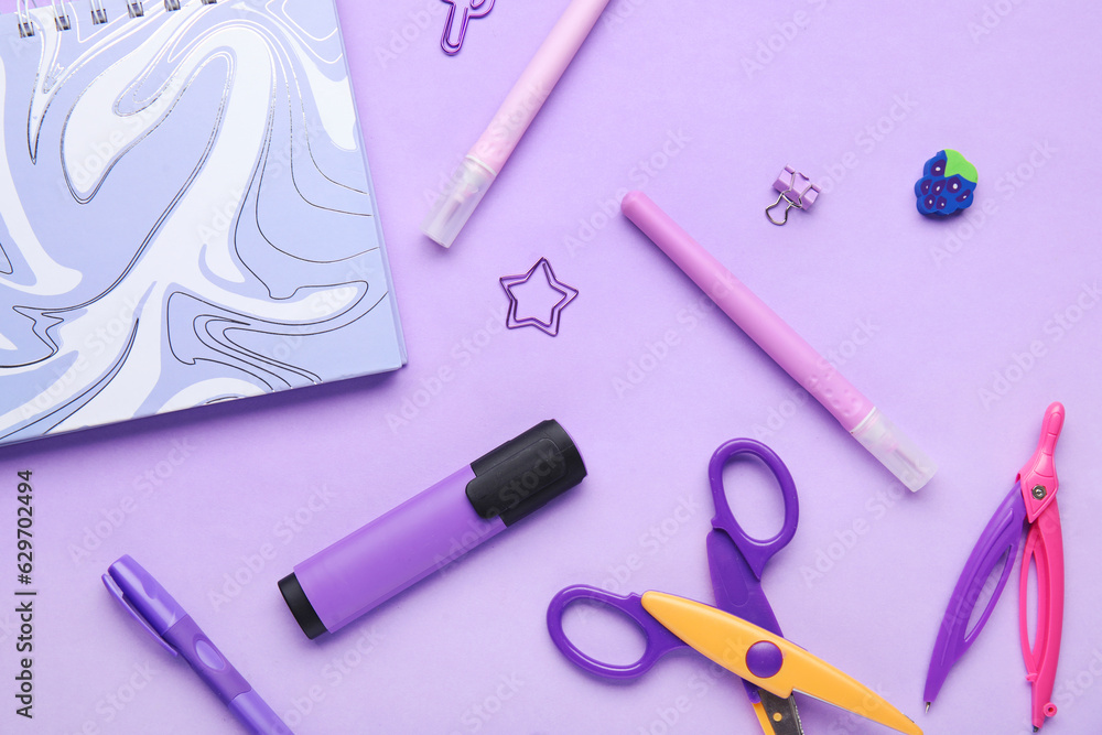 Composition with different stationery on lilac background