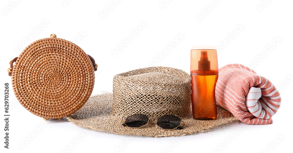 Beach accessories and bottle of sunscreen on white background