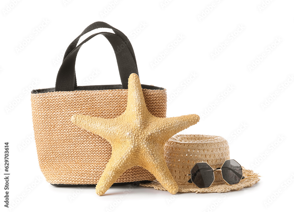 Stylish female bag, hat, sunglasses and starfish on white background