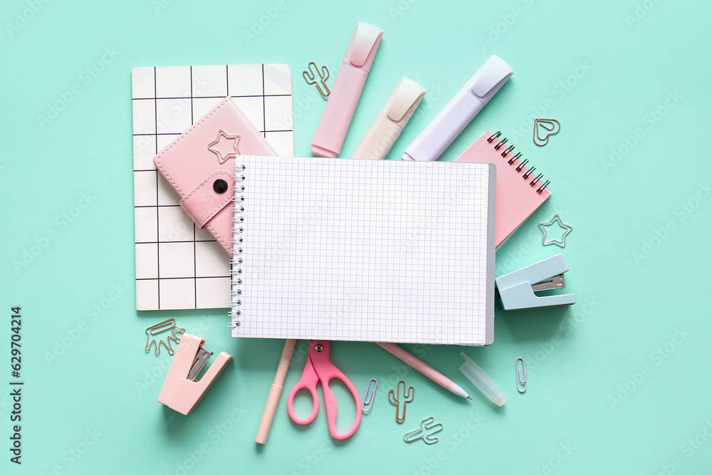 Composition with blank notebook and different school stationery on turquoise background