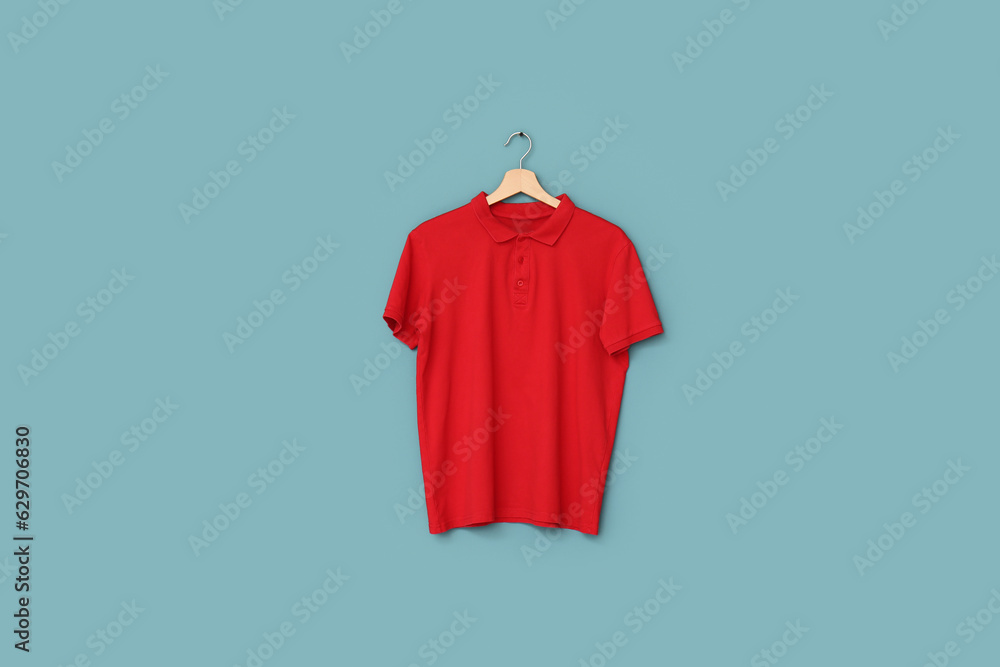 Stylish red t-shirt hanging on blue background