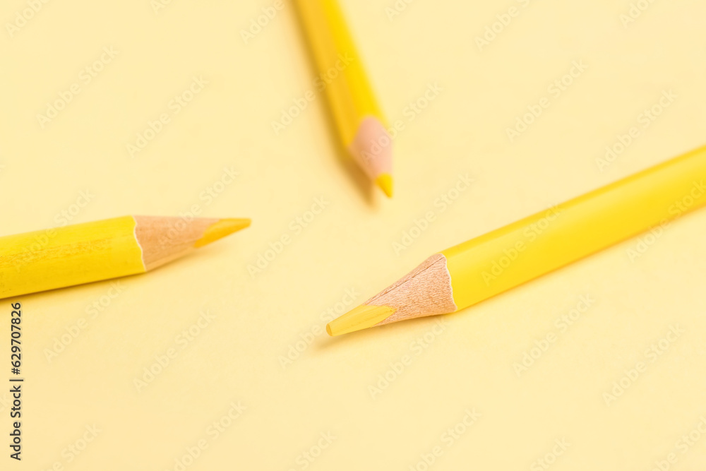 Three yellow pencils on color background, closeup