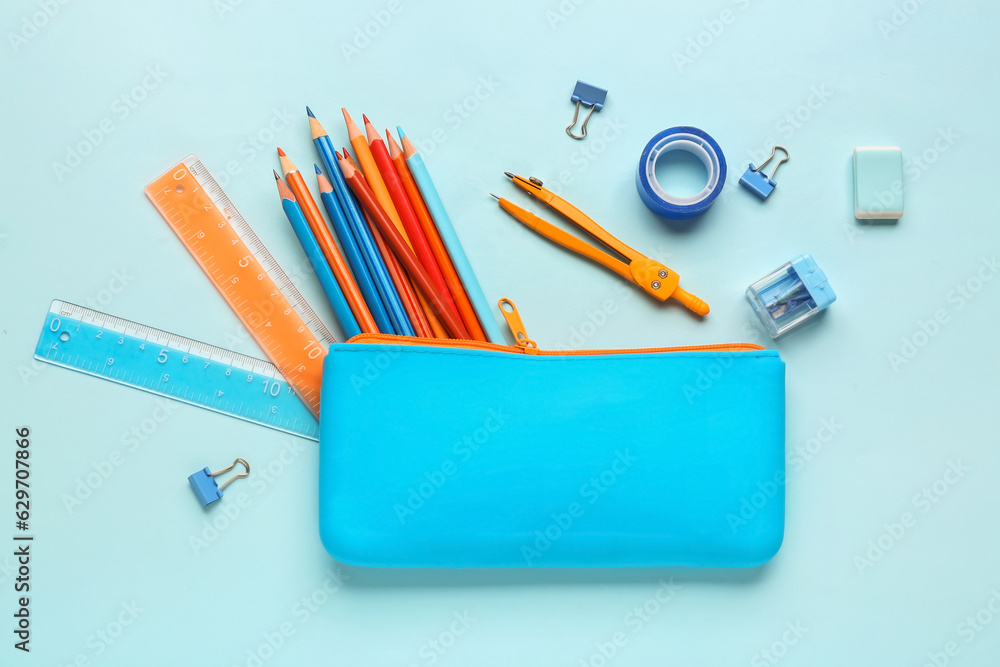 Composition with pencil case and different stationery on color background