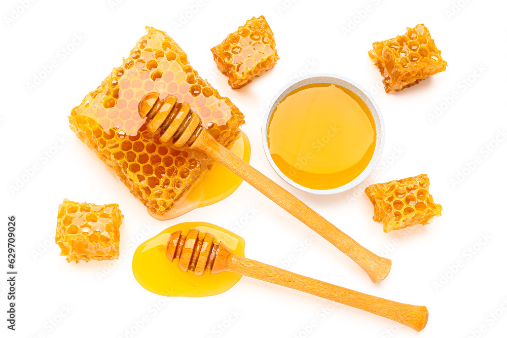 Bowl of sweet honey, dippers and combs on white background