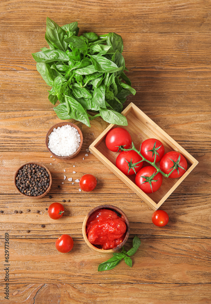 Composition with spices, basil, fresh and canned tomatoes on wooden background