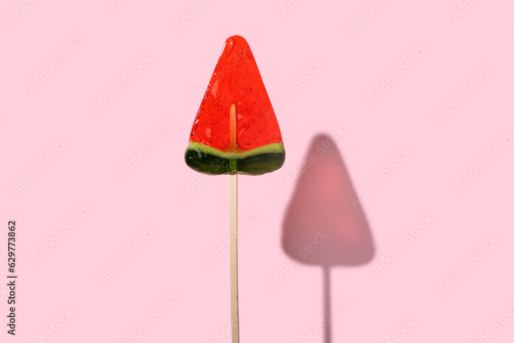 Lollipop in shape of watermelon slice on pink background