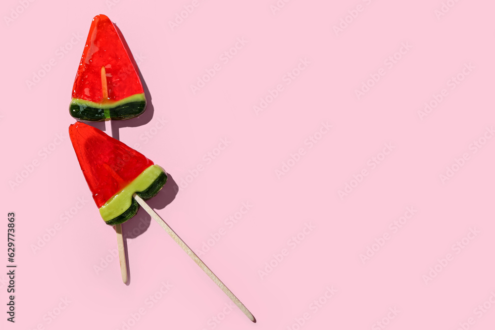 Lollipops in shape of watermelon slice on pink background