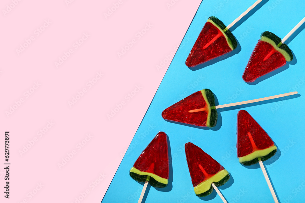 Lollipops in shape of watermelon slice on colorful background