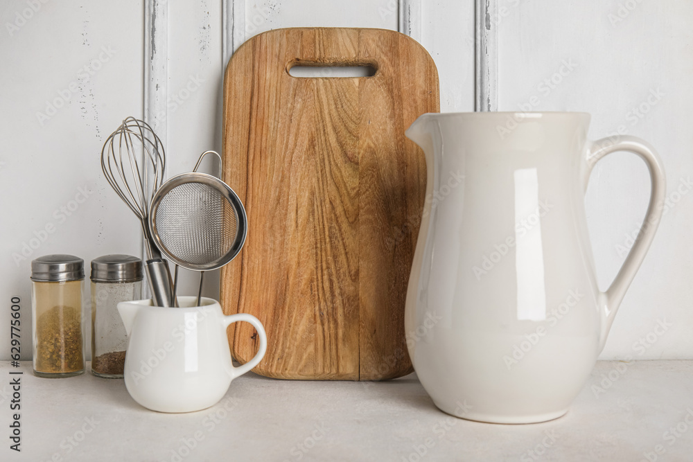 Set of different kitchen utensils and spices on light table