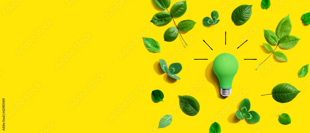 Green light bulb with green leaves - Flat lay