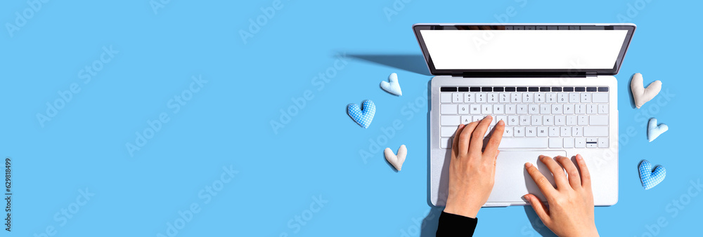 Laptop computer with heart cushions - flat lay