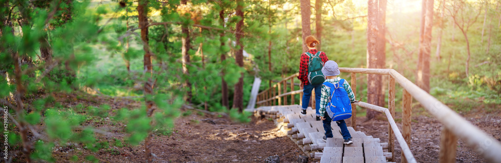 Mother ans son walking down on staircase in natural park.