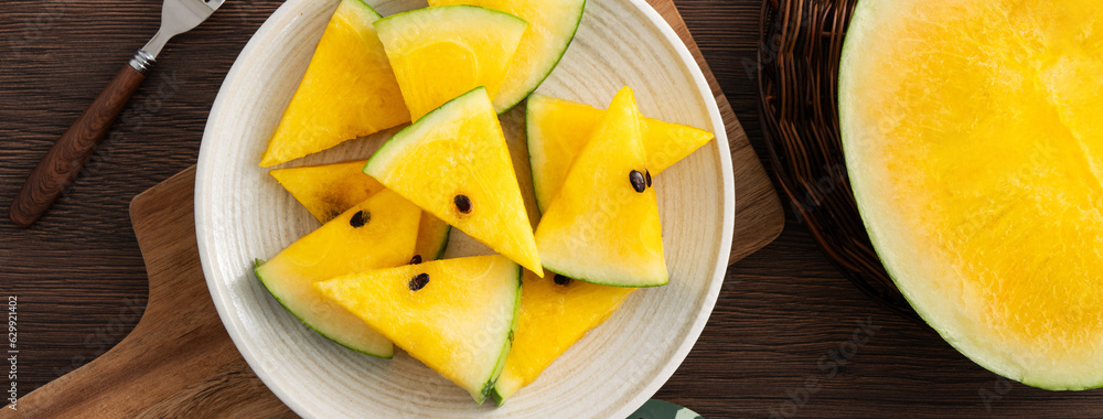 Sliced yellow watermelon pattern flat lay on wooden table background.