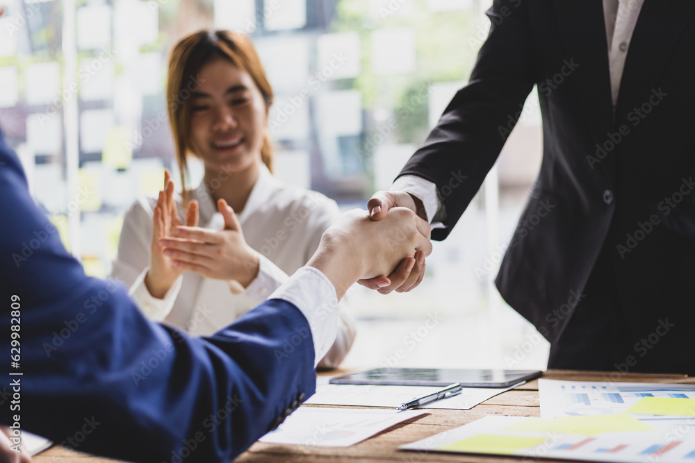 Business meeting, businesswomen shaking hands in business partnership meeting.