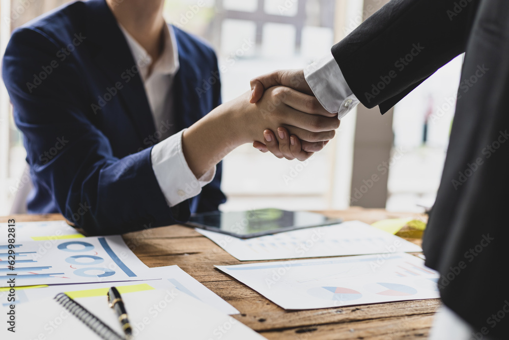 Business meeting, businesswomen shaking hands in business partnership meeting.