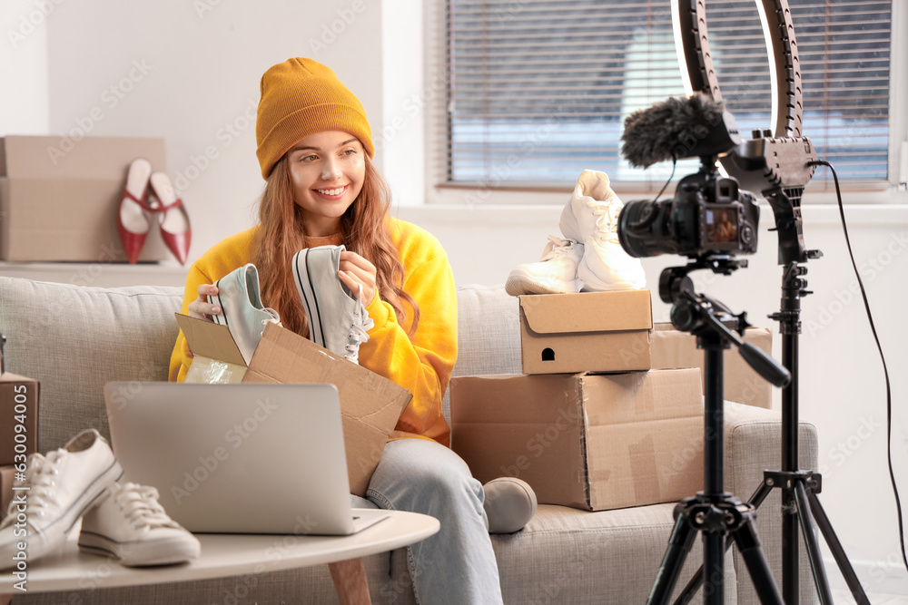 Female seller with shoes recording video at home