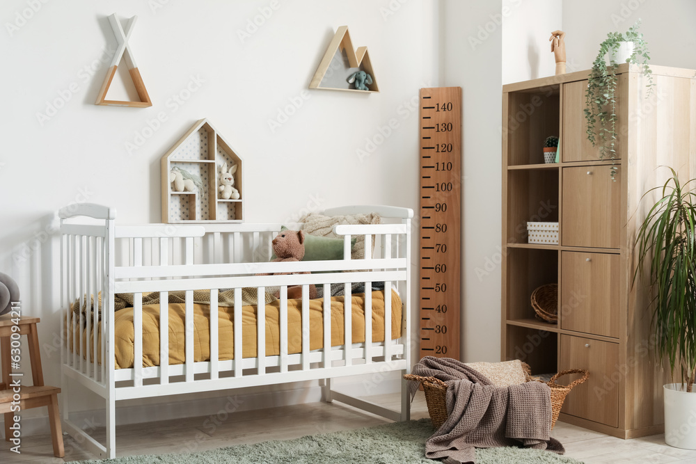 Interior of childrens bedroom with crib, shelves and toys