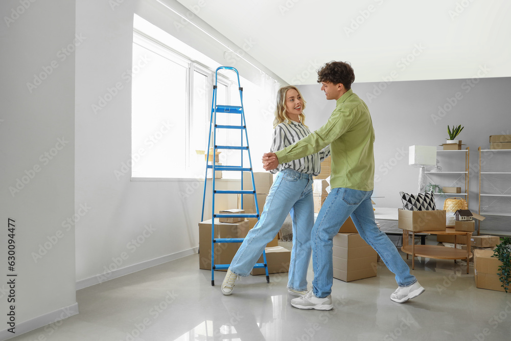 Young couple dancing in bedroom on moving day