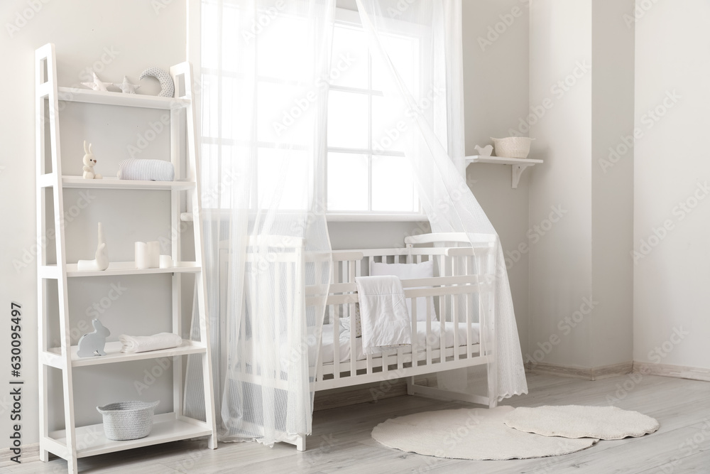 Interior of stylish childrens bedroom with crib and shelving unit