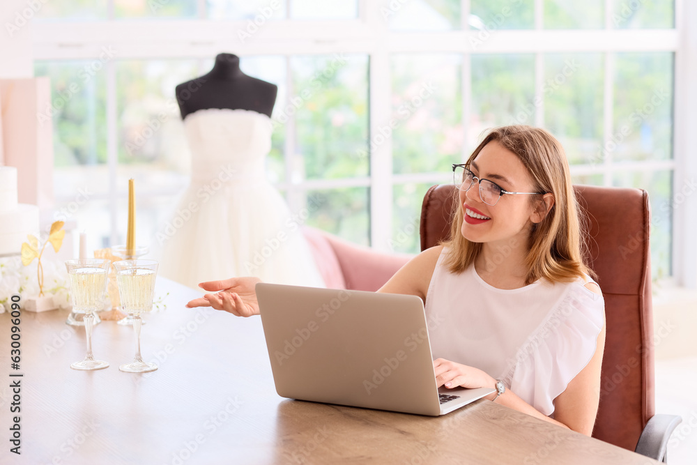 Female wedding planner working with laptop in office