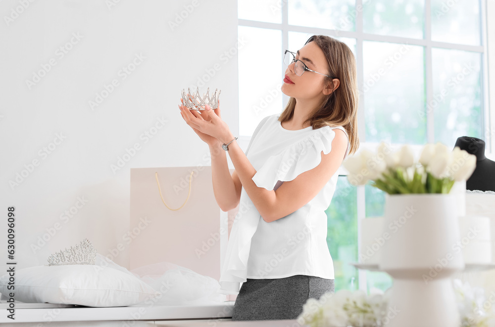 Female wedding planner with crown in office