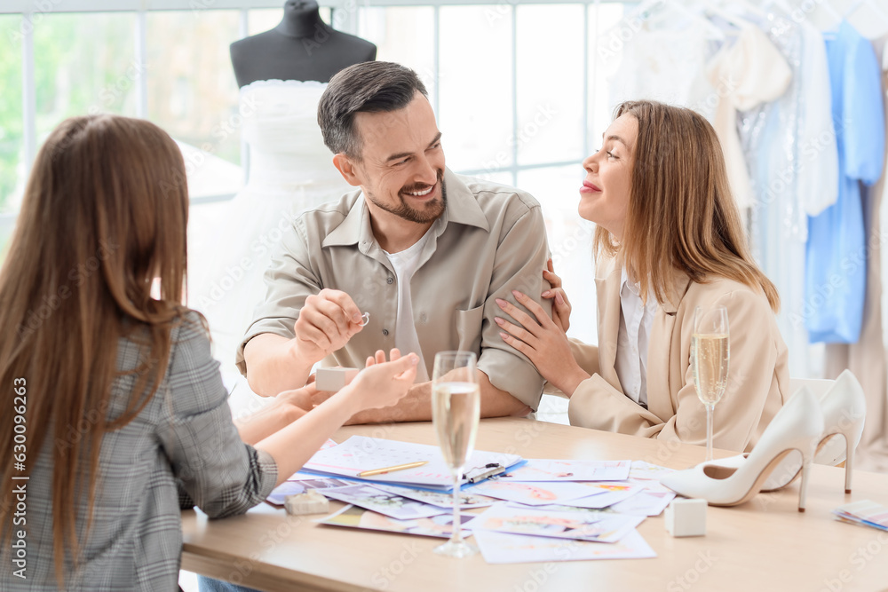 Young couple choosing ring for their wedding in office