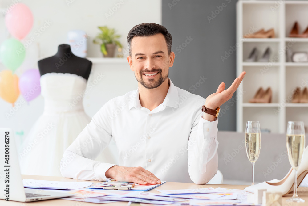 Male wedding planner working at table in office