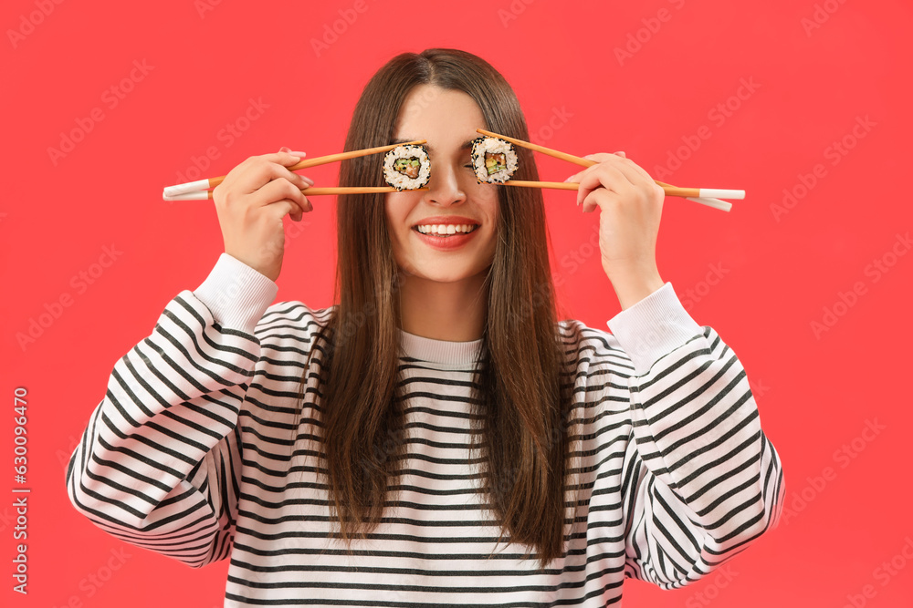 Young woman with sushi on red background