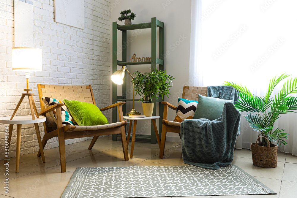 Interior of living room with glowing lamps and armchairs