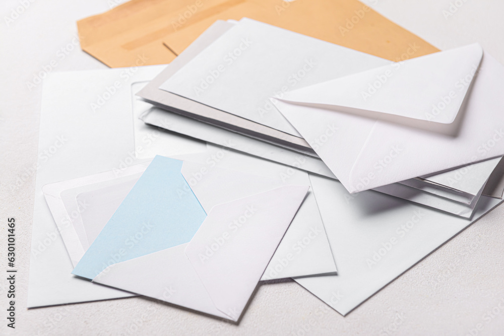 Heap of envelopes and card on light background, closeup