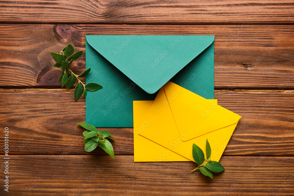 Composition with envelopes and plant branches on wooden background