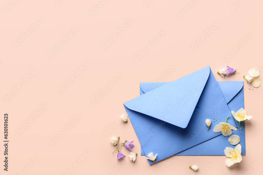 Composition with envelopes and beautiful flowers on color background