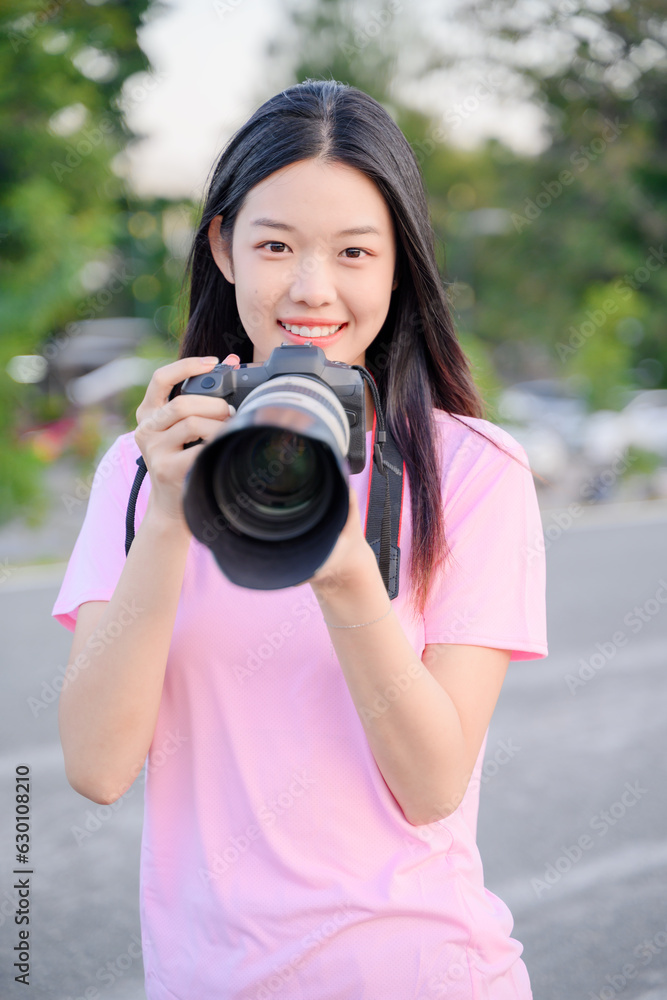 beautiful happy asian woman photographer holding professional camera with telephoto lens