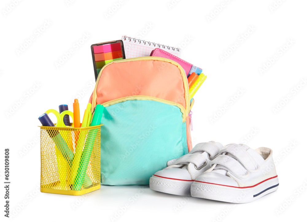 Colorful school backpack with different stationery and sneakers on white background