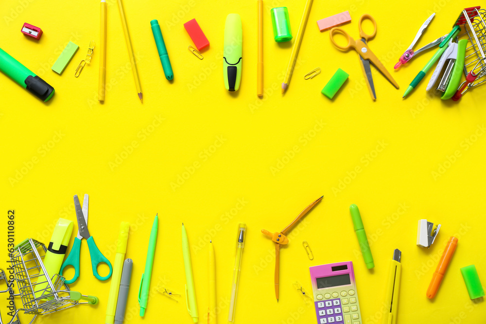 Shopping carts with different stationery on yellow background