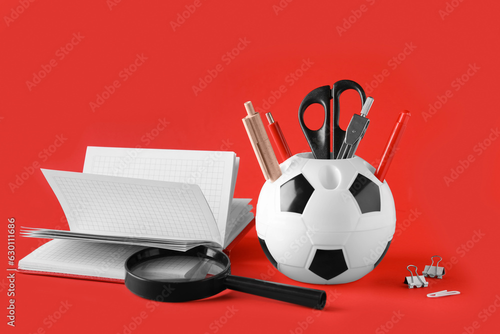 Stylish holder with different stationery on red background