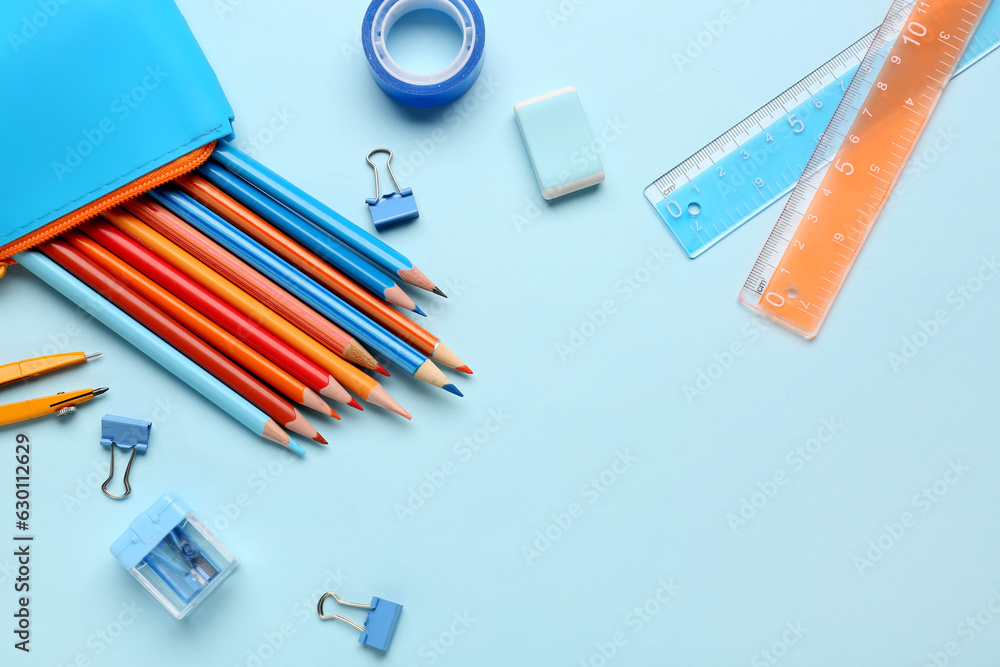 Composition with pencil case and different stationery on color background