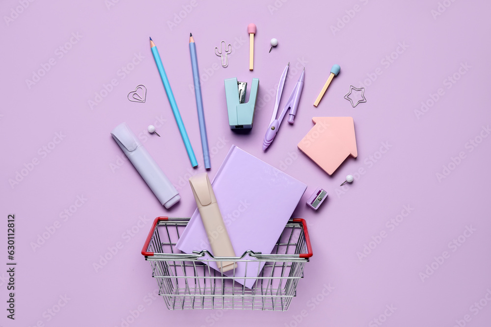 Composition with shopping basket and different stationery on lilac background