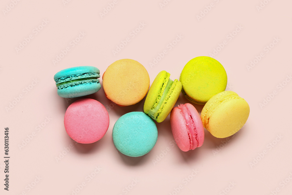 Different tasty sweet macaroons on pink background