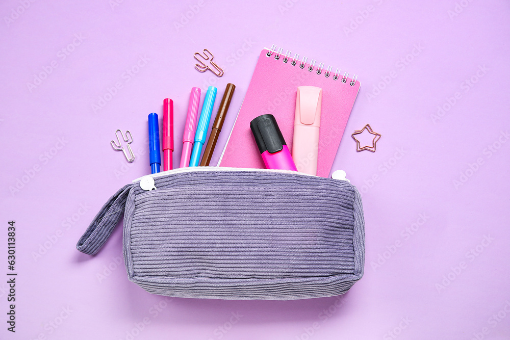 Pencil case with different school stationery on purple background