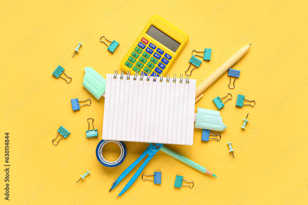 Notebook with different stationery supplies on yellow background