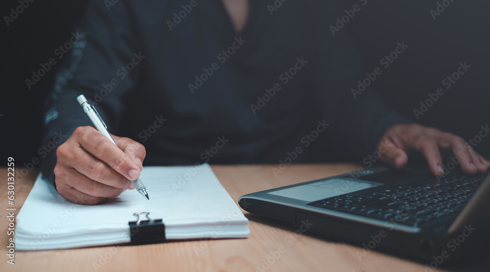 Businessman writing on note paper and work on laptop computer, E-learning, online education, Busines