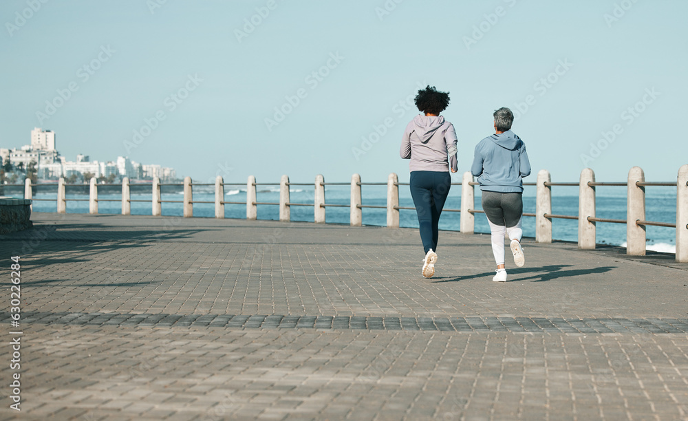 Back view, beach and women running for fitness together as morning exercise for wellness and outdoor