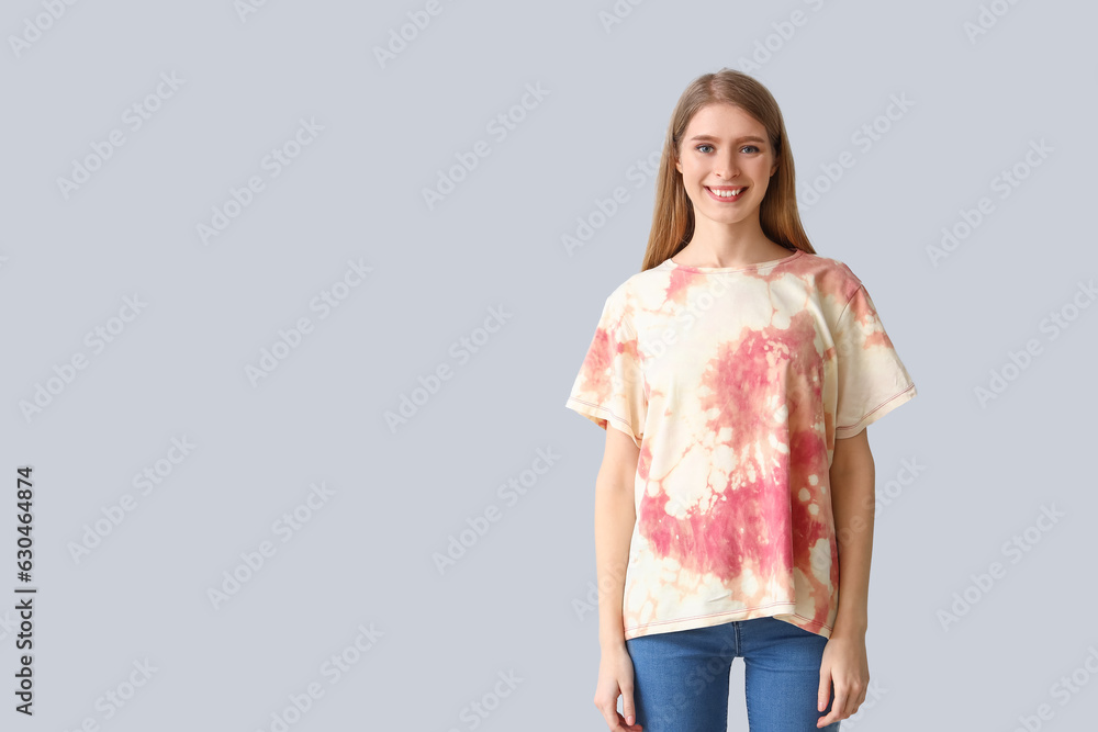 Young woman in tie-dye t-shirt on light background