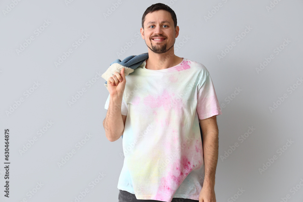 Handsome man in tie-dye t-shirt on light background