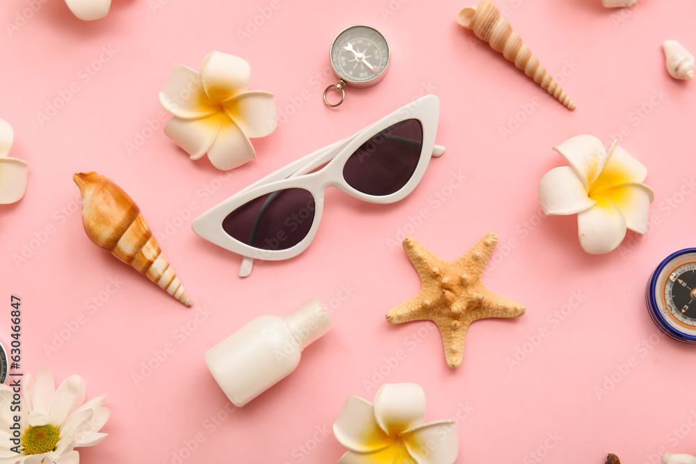 Composition with sunglasses, plumeria flowers, seashells and starfish on pink background