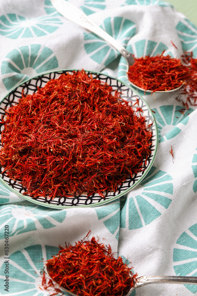 Plate and spoons with pile of saffron on napkin