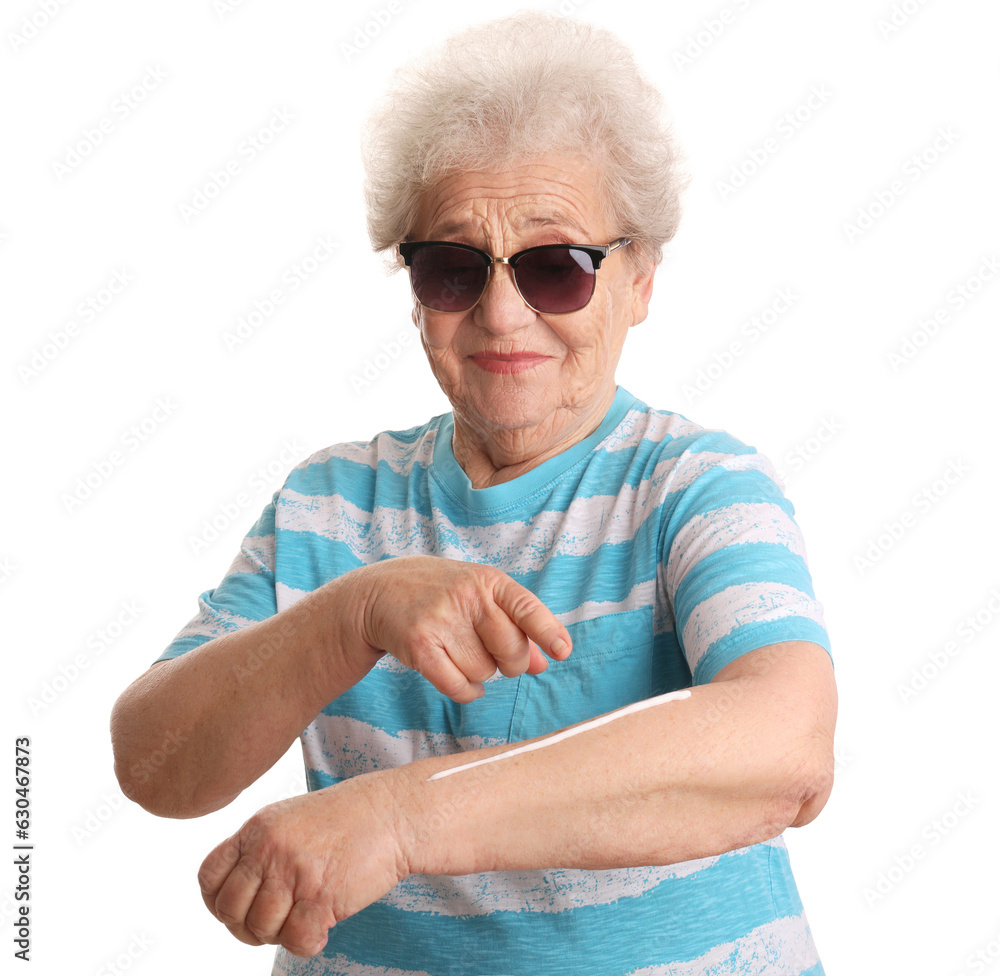 Senior woman applying sunscreen cream on white background