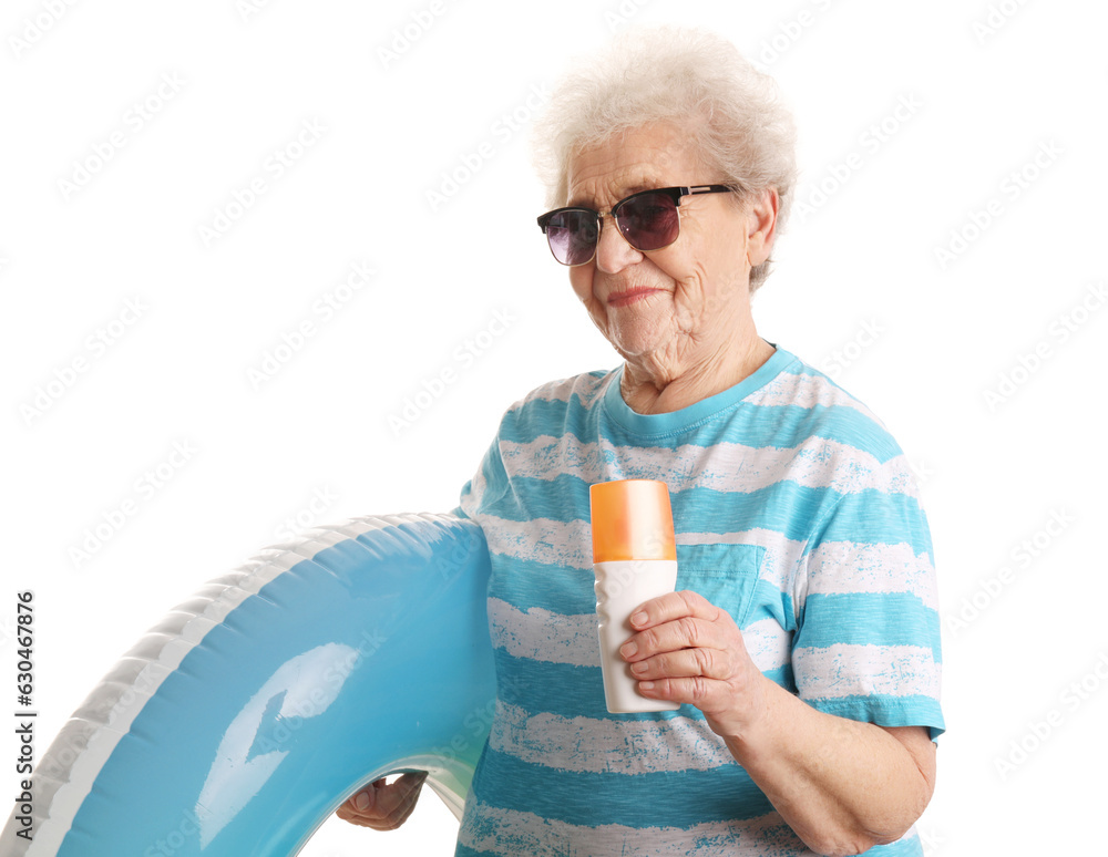 Senior woman with sunscreen cream and inflatable ring on white background