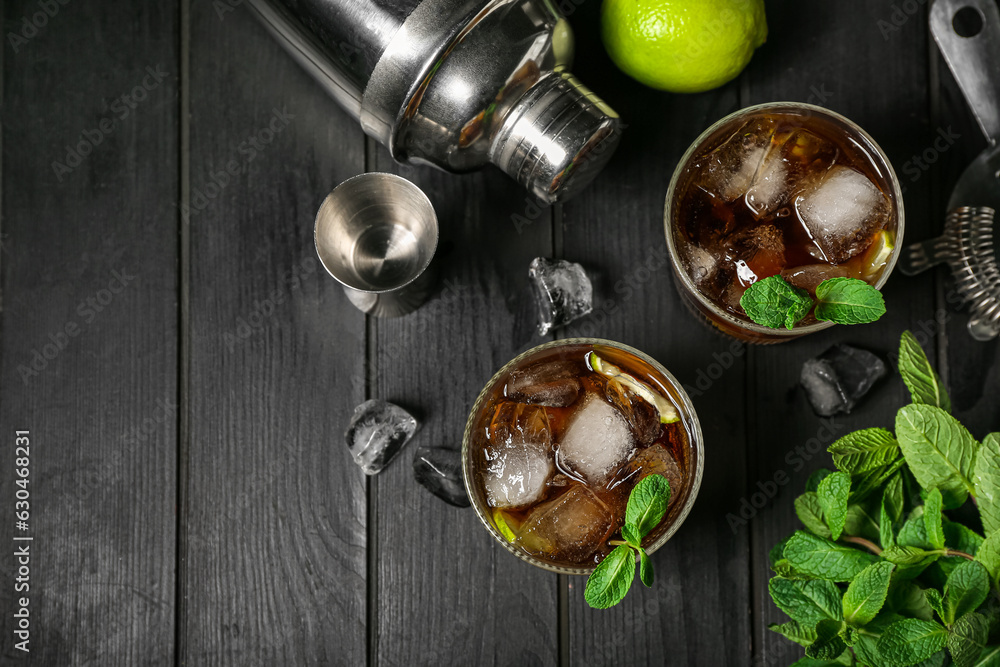 Glasses of cold Cuba Libre cocktail on dark wooden background